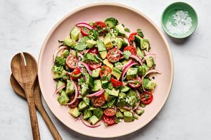 avocado salad made with tomatoes, cucumbers, serrano pepper, herbs and homemade vinaigrette topped with flaky salt