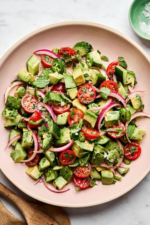 avocado salad made with tomatoes, cucumbers, serrano pepper, herbs and homemade vinaigrette topped with flaky salt