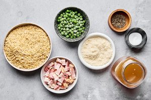 ingredients laid out to make bacon pea creamy orzo including orzo, peas, bacon, Parmesan, slat, pepper and chicken broth