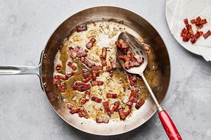 chopped bacon being cooked in a skillet
