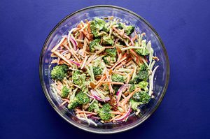 A bowl of fresh broccoli slaw with shredded carrots and cranberries and almonds, tossed in a light dressing.