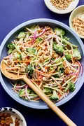 A bowl of fresh broccoli slaw with shredded carrots and cranberries and almonds, tossed in a light dressing.