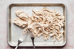 cooked chicken breast being shredded to make chipotle chicken flautas, an easy weeknight dinner
