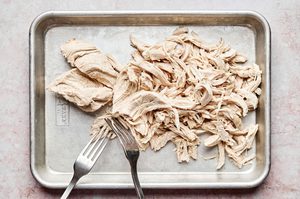 cooked chicken breast being shredded to make chipotle chicken flautas, an easy weeknight dinner