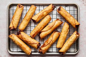 deep fried chipotle chicken flautas cooking on a wire rack