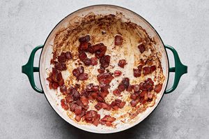 chopped bacon being cooked in butter in a soup pot to make a flavorful base for corn chowder