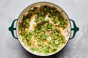 green onion, celery, garlic and bay leaf cooking in butter and reserved bacon fat to make a flavorful base for corn chowder