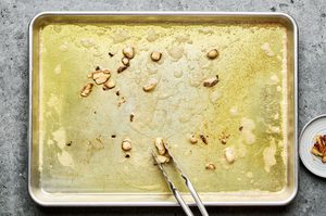olive oil, butter and garlic cloves heating on a sheet pan