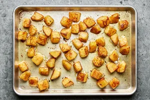 crispy roasted potatoes cooked in olive oil, garlic and salt on a sheet pan hot out of the oven