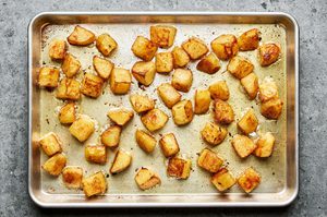 crispy roasted potatoes cooked in olive oil, garlic and salt on a sheet pan hot out of the oven