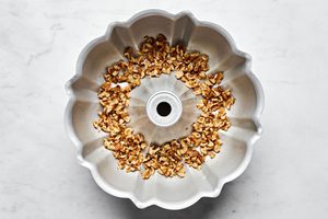chopped walnuts layering the bottom of a greased bundt pan ready to make homemade monkey bread