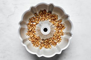 chopped walnuts layering the bottom of a greased bundt pan ready to make homemade monkey bread