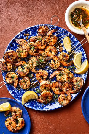 Garlic butter grilled shrimp sprinkled with fresh parsley served on a plate with lemon wedges, a perfect summer seafood meal