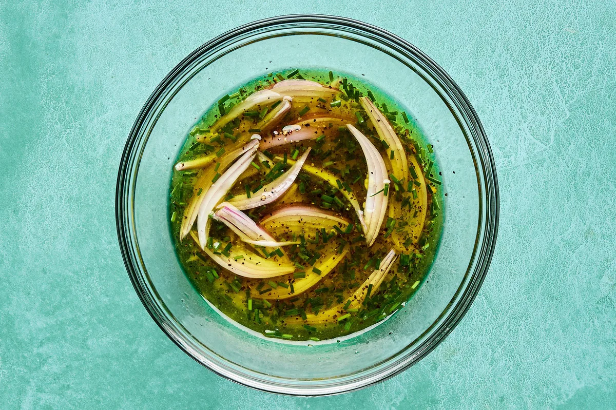 a bowl of honey dijon dressing to be used on a vibrant green bean salad