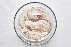seasoned chicken breasts marinating in balsamic mayo to make an italian inspired grilled chicken sandwich