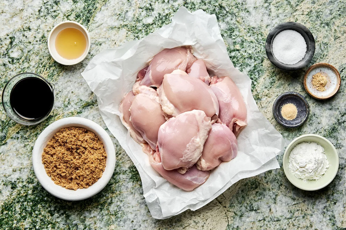 Ingredients for grilled teriyaki chicken laid out, including chicken, soy sauce, ginger, garlic, brown sugar, salt and honey