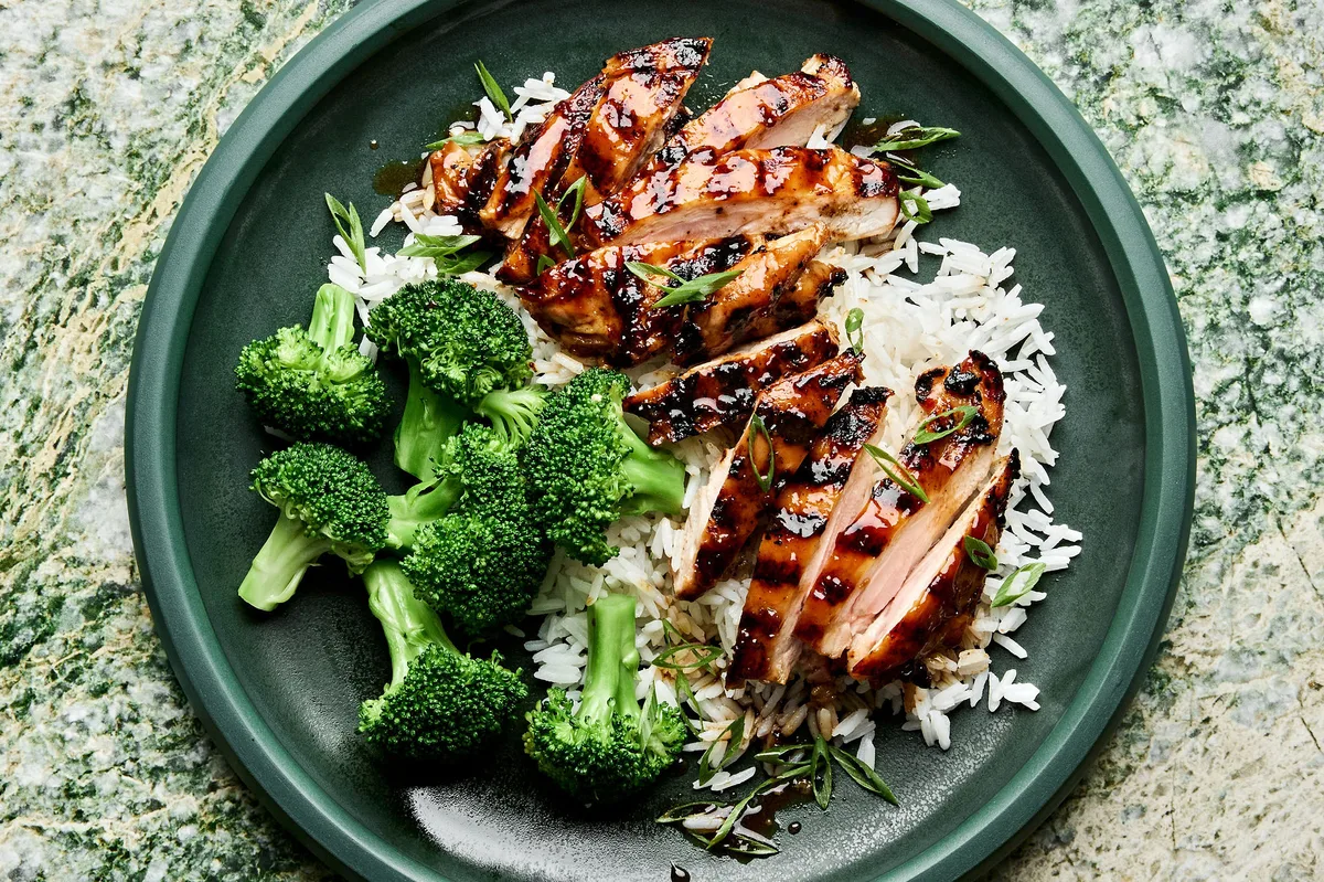 homemade grilled teriyaki chicken served on top of fluffy white rice with a side of steamed broccoli