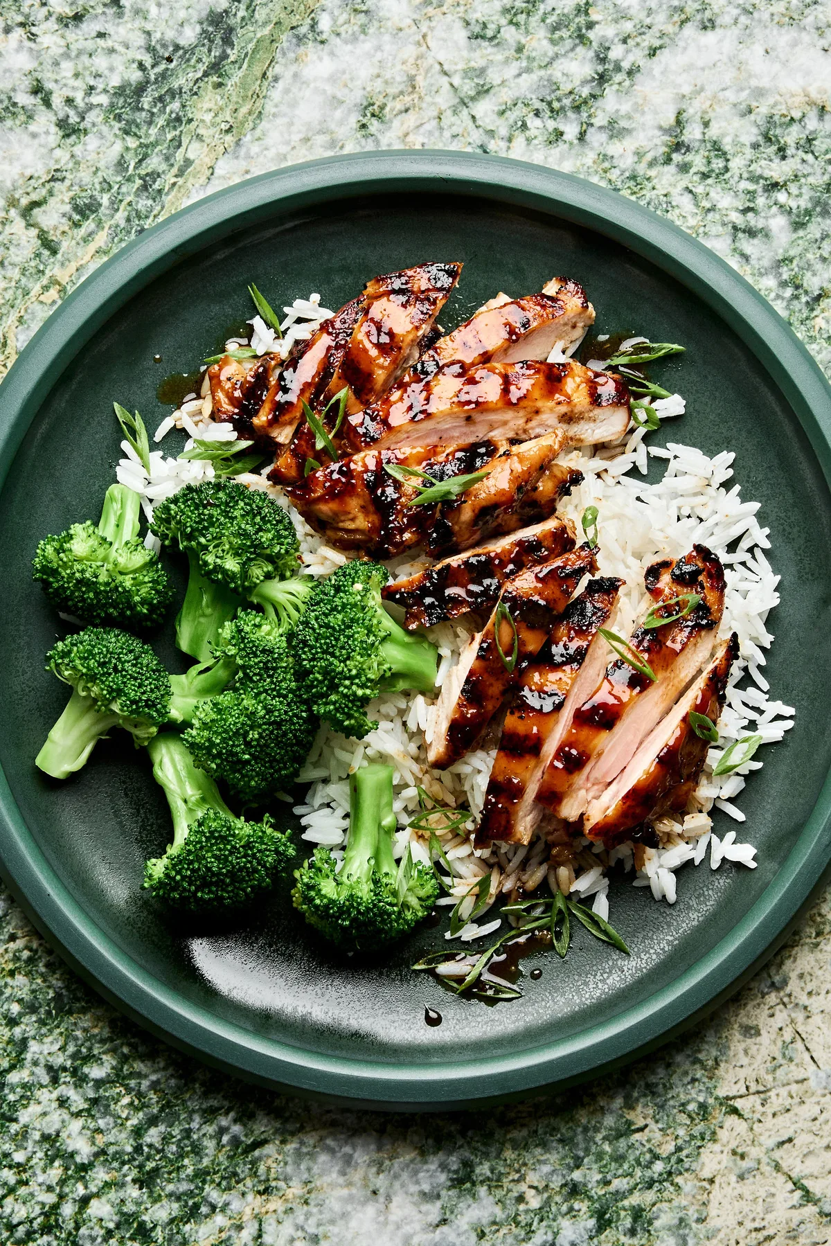 homemade grilled teriyaki chicken served on top of fluffy white rice with a side of steamed broccoli