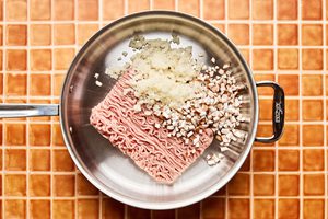 ground turkey, cauliflower rice and mushrooms cooking in a skillet to make ground turkey stir fry, a healthy, low-carb dinner