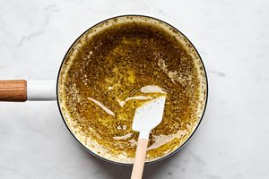 butter and herbs melting in a saucepan to make dressed up rhodes rolls