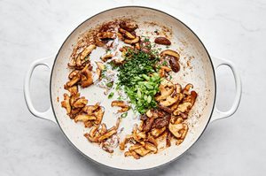miso and mushroom cream sauce being made in a skillet to be served over pork chops