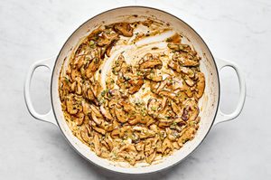 miso and mushroom cream sauce being made in a skillet to be served over pork chops
