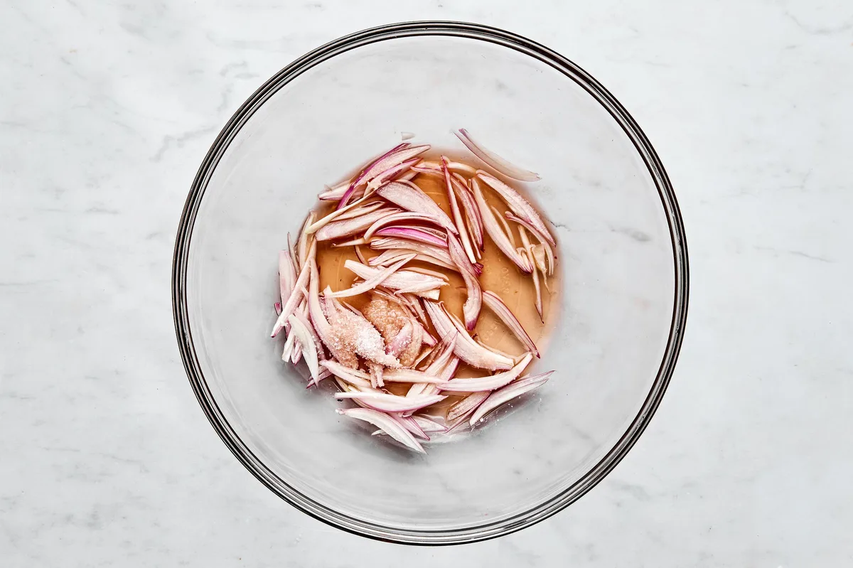 red wine vinegar, shallot, and salt being mixed in a bowl