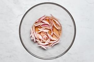 red wine vinegar, shallot, and salt being mixed in a bowl