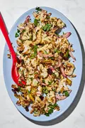 Roasted cauliflower salad with herbs, almonds, dried cherries, and spices on a serving plate.