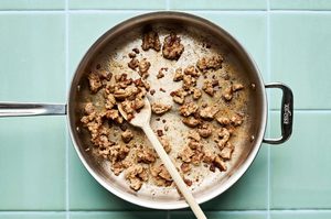 italian chicken sausage browning in a skillet to use in a quick and easy sausage, cabbage and white bean skillet recipe
