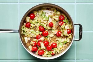 chopped cabbage, cherry tomatoes and garlic cooking in a skillet to make a quick &  easy one pan dinner