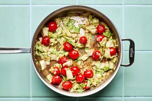chopped cabbage, cherry tomatoes and garlic cooking in a skillet to make a quick & easy one pan dinner