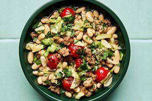 Italian sausage, cabbage, and white bean skillet served in a bowl with cherry tomatoes and fresh herbs, easy 20 minute recipe