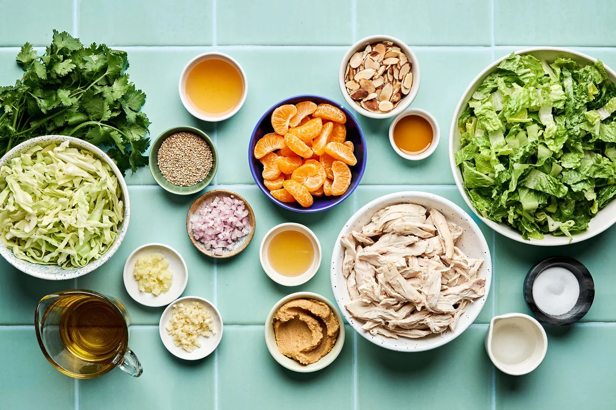 ingredients laid out for a light and healthy sesame chicken salad with miso dressing