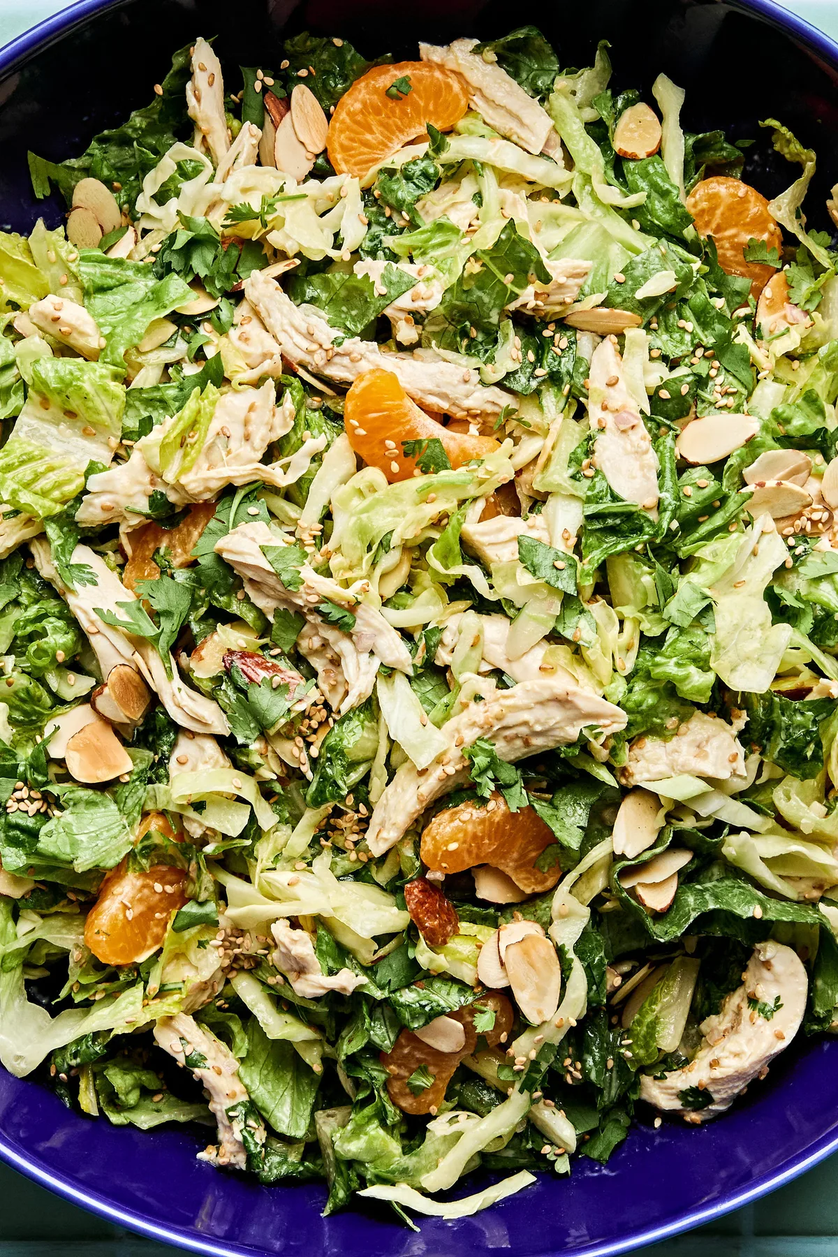 Bright sesame chicken salad with juicy orange slices and sliced almonds with a homemade miso dressing
