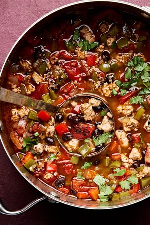 a pot of healthy and hearty southwest turkey & quinoa soup with black beans, bell peppers and fire roasted tomatoes