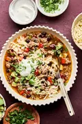 Bowl of Healthy Southwest turkey quinoa soup topped with sour cream, avocado, cilantro, and green onion. A hearty dinner.