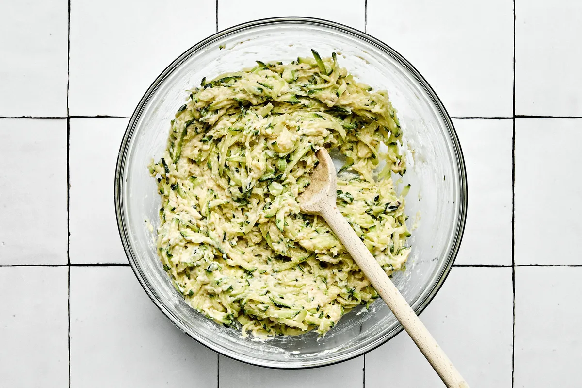 a bowl of zucchini fritter batter ready to be cooked in oil