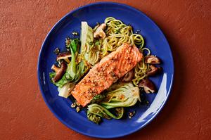 garlic ginger salmon on a plate with zucchini noodles, bok choy and shitake mushrooms
