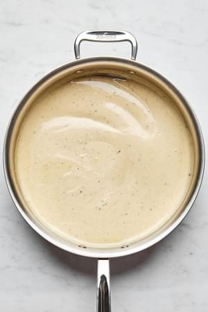 alfredo sauce in a skillet made with Butter, cream, garlic, garlic powder, nutmeg, and Parmesan