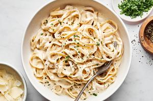 homemade alfredo sauce tossed with fettuccine noodles topped with fresh parsley