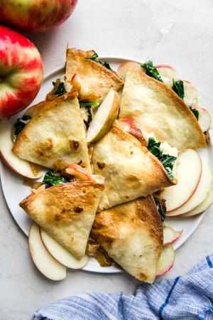 Apple and Caramelized Onion Baked Quesadilla with spinach on a plate