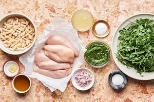 arugula, 4 raw chicken breasts, pesto, white beans, lemon juice, dijon, sugar, salt, olive oil and shallot in prep bowls