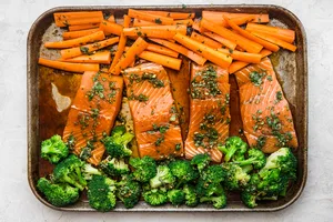 Baking sheet with carrots, salmon and broccoli with a teriyaki sauce
