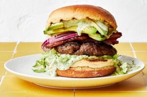 a homemade avocado burger with bacon, lettuce, red onion and jalapeño aioli