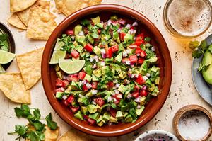 avocado salsa made with tomato, red onion, jalapeño, cilantro, lime juice and spices surrounded by tortilla chips