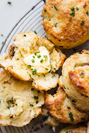 bacon cheddar and chive scones on a wire baking rack with chive butter