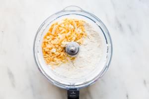 butter, flour, baking soda, baking powder and cheddar in the base of a food processor