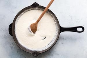 chicken stock, cream cheese and mozzarella stirred together in a cast iron skillet
