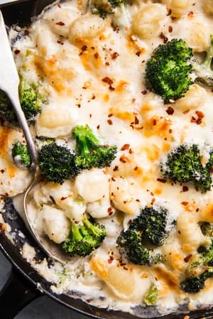 cheesy Baked Gnocchi with broccoli in a cast iron skillet